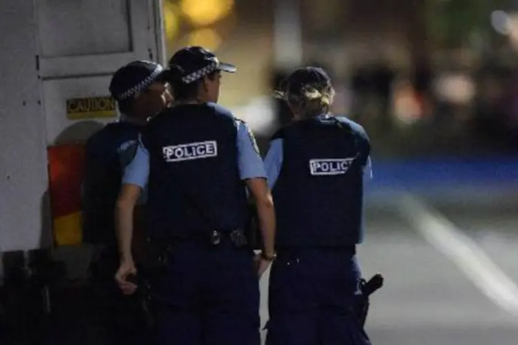 Oficiais da polícia são vistos durante a operação do café no centro de Sydney (Saeed Khan/AFP)