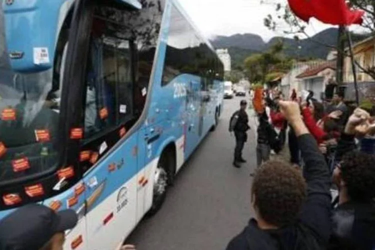 
	&Ocirc;nibus com os jogadores da sele&ccedil;&atilde;o chega &agrave; Granja Comary: manifestantes colaram no ve&iacute;culo adesivos com palavras de ordem contra a Copa e chegaram a vaiar os atletas
 (AFP)