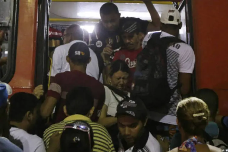 Passageiros tentam embarcar e desembarcar de ônibus lotado em Recife (REUTERS/Ricardo Moraes)