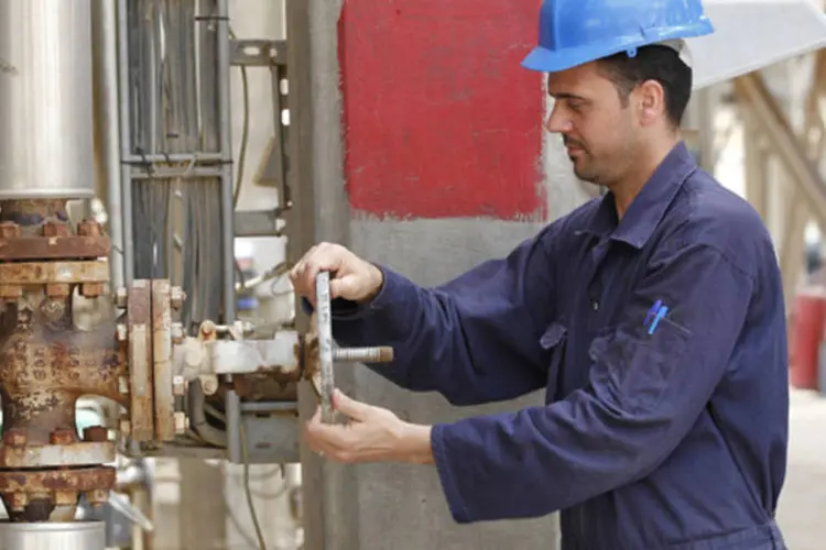 Trabalhador ajusta válvula de um oleoduto na refinaria de Al-Doura, em Bagdá, em abril de 2012 (Mohammed Ameen/Reuters)