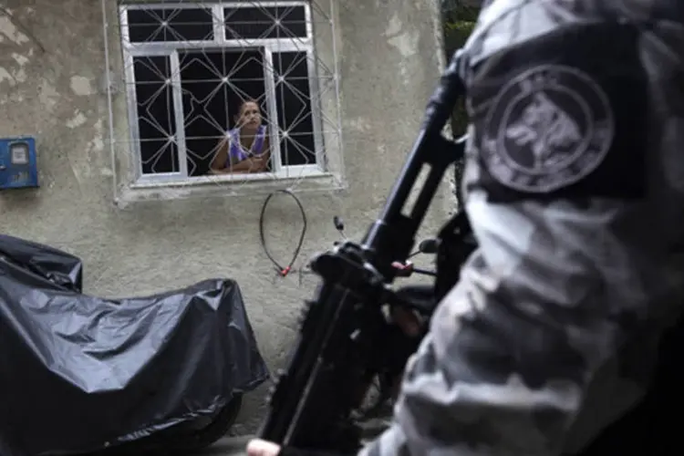 
	Morador olha policial durante a&ccedil;&atilde;o no Complexo de favelas da Mar&eacute;: menor repassava as informa&ccedil;&otilde;es dos militares para os traficantes utilizando um r&aacute;dio transmissor
 (Ricardo Moraes/Reuters)