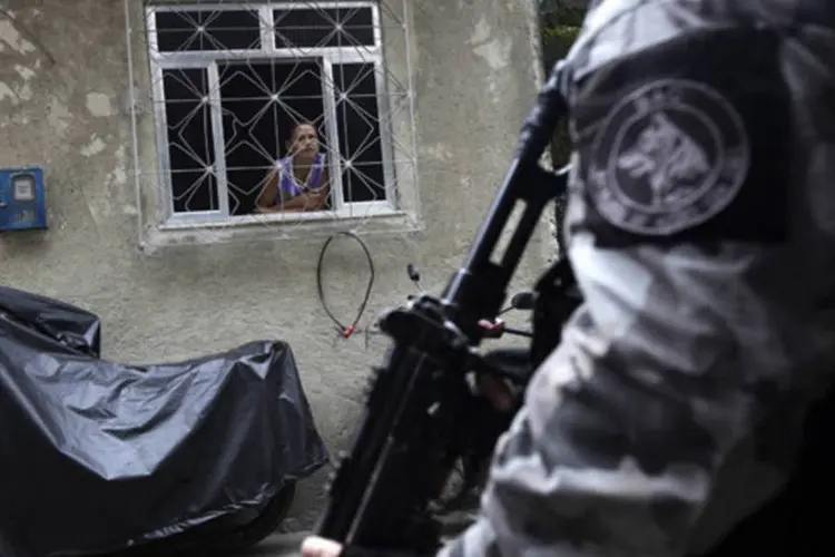 
	Morador olha policial durante a&ccedil;&atilde;o no Complexo de favelas da Mar&eacute;, no Rio
 (Ricardo Moraes/Reuters)