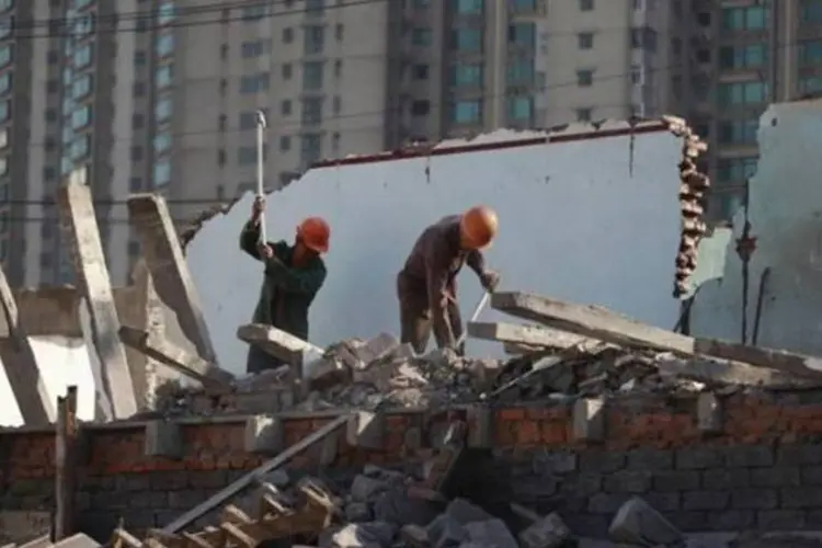 Funcionários trabalham em área residencial demolida, em Xangai, na China (Aly Song/Reuters)