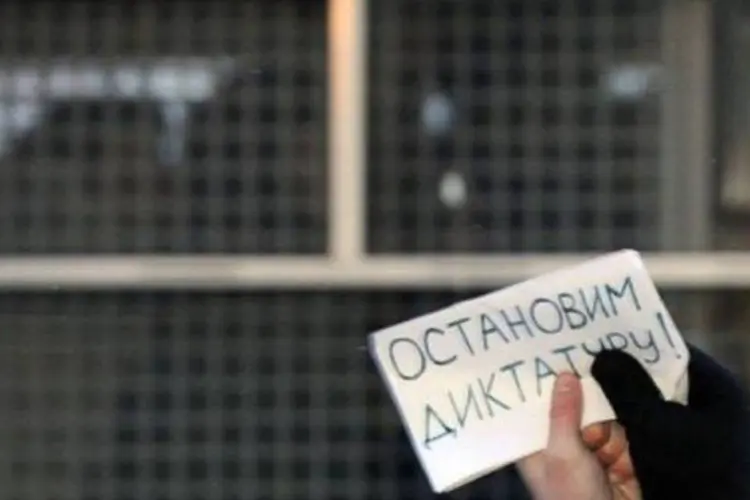 Manifestantes exibem papel com a frase "Parem a ditadura!" (Kirill Kudryavtsev/AFP)