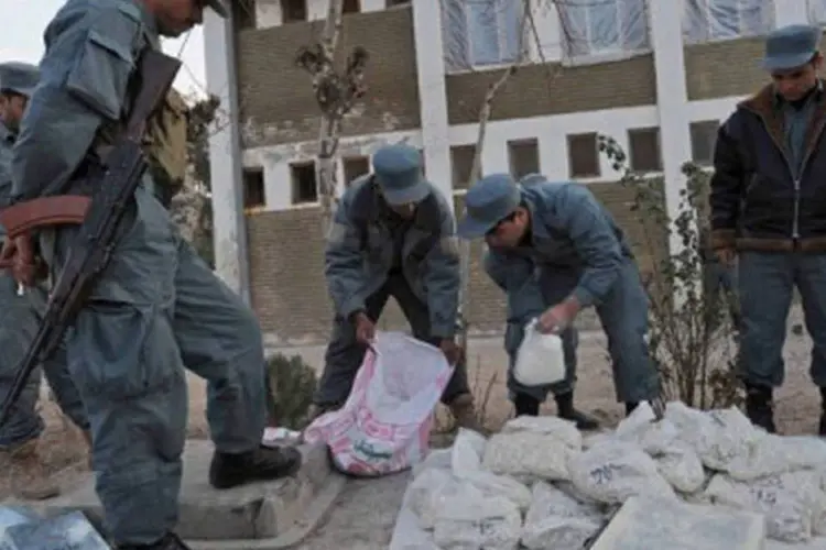 Policiais afegãos observam sacos de ópio: após uma leve queda da parte afegã na produção global de 2010, o país deverá representar mais uma vez 90% da produção mundial de ópio (Aref Karimi/AFP)
