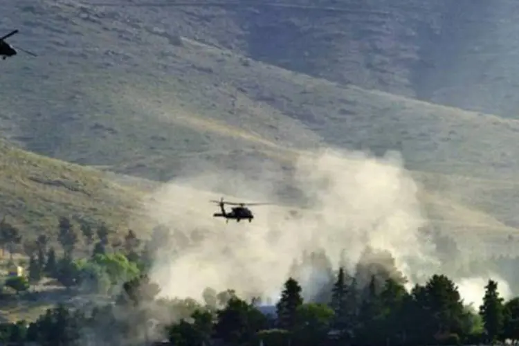 Helicópteros da Otan sobrevoam o hotel Spozhmai no lago Qargha: a organização acusa a rede Haqqani de ter organizado o ataque (Massoud Hossaini/AFP)