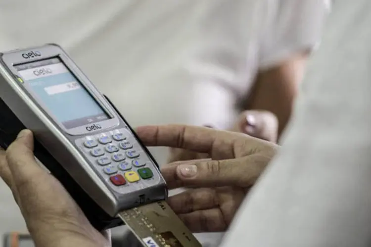 Caixa usa uma máquina da Cielo para processar um pagamento com cartão de crédito, em São Paulo (Paulo Fridman/Bloomberg)