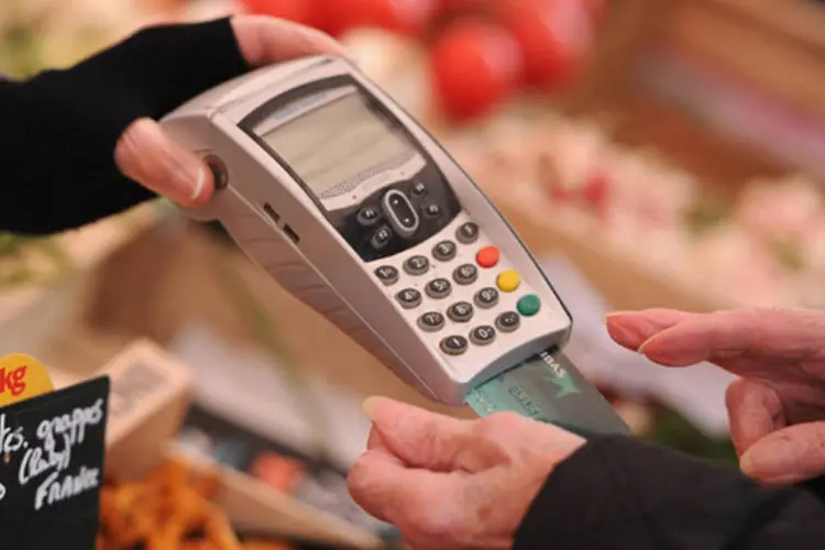 
	Mulher faz o pagamento de suas contas com um cart&atilde;o de cr&eacute;dito em uma loja de frutas
 (Pascal Le Segretain/Getty Images)