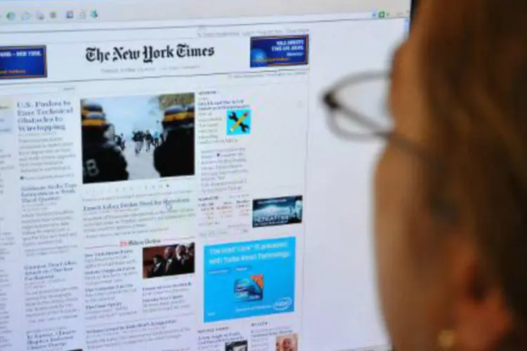 Uma mulher é vista lendo a página principal do New York Times na internet, em Washington, DC (Karen Bleier/AFP)