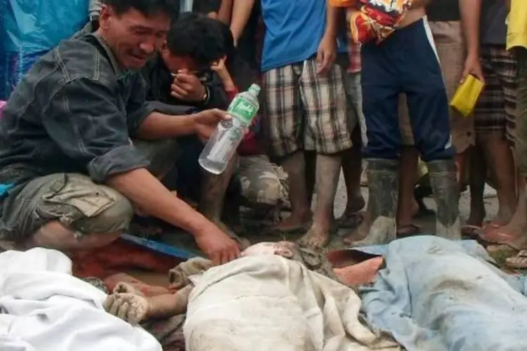 Pai chora ao encontrar filho morto na cidade de New Bataan, nas Filipinas (Reuters)
