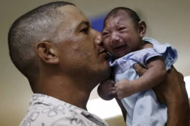 
	Pai segura beb&ecirc; com microcefalia
 (Ueslei Marcelino / Reuters)
