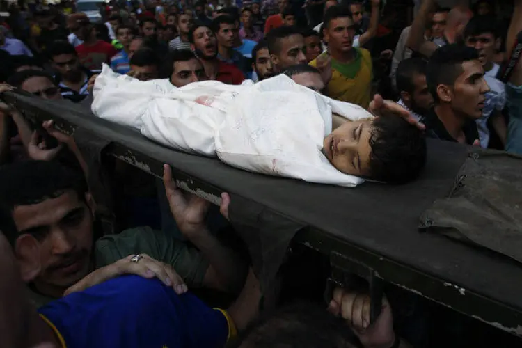 Corpo de menino palestino, vítima de explosão em Gaza, é carregado durante funeral (Mohammed Salem/Reuters)