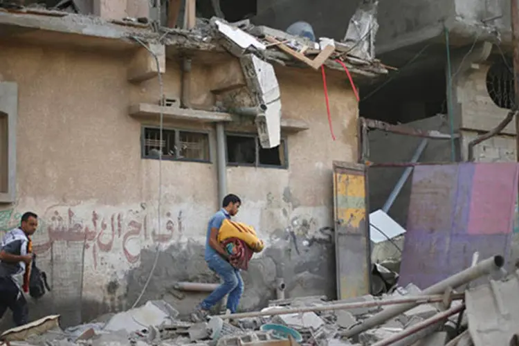 Palestinos evacuam casa atingida por ataques israelenses (REUTERS/Mohammed Salem)