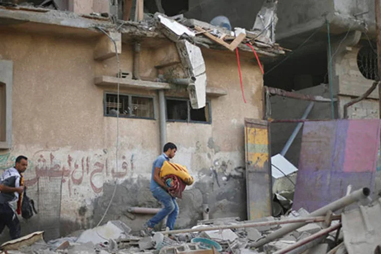 Palestinos evacuam casa atingida por ataques israelenses (REUTERS/Mohammed Salem)