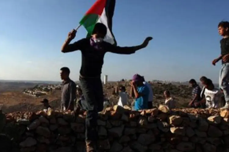 Palestinos mortadores de Deir Qadis, na Cisjordânia, protestam contra assentamento judeu em 29 de junho (Abbas Momani/AFP)