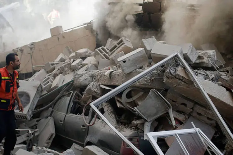 
	Bombeiro participa de esfor&ccedil;os para extinguir fogo em uma casa destru&iacute;da devido ap&oacute;s ataque israelense
 (REUTERS/Mohammed Salem)