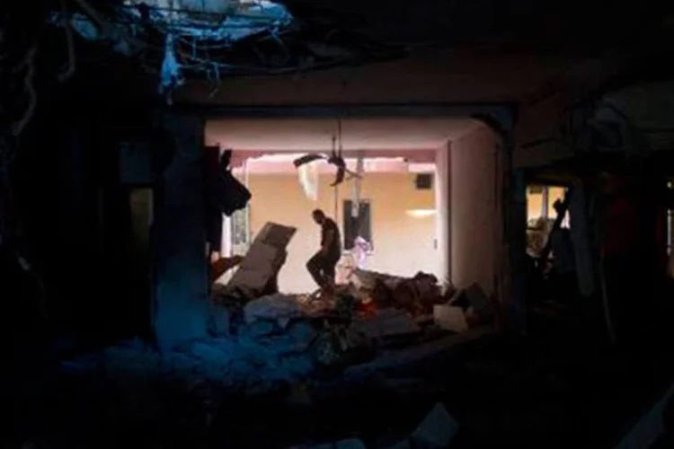 Palestino caminha por casa destruída após bombardeio noturno israelense na cidade de Gaza
 (Mahmud Hams/AFP)