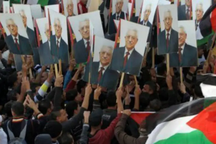 
	Palestinos exibem cartazes com fotos do presidente da Autoridade Palestina, Mahmud Abbas, na Cisjord&acirc;nia
 (©AFP/Arquivo / Abbas Momani)