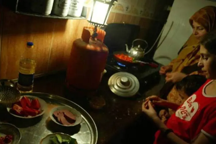 
	Mulheres cozinham &agrave; luz de lampi&atilde;o na Palestina
 (Getty Images)