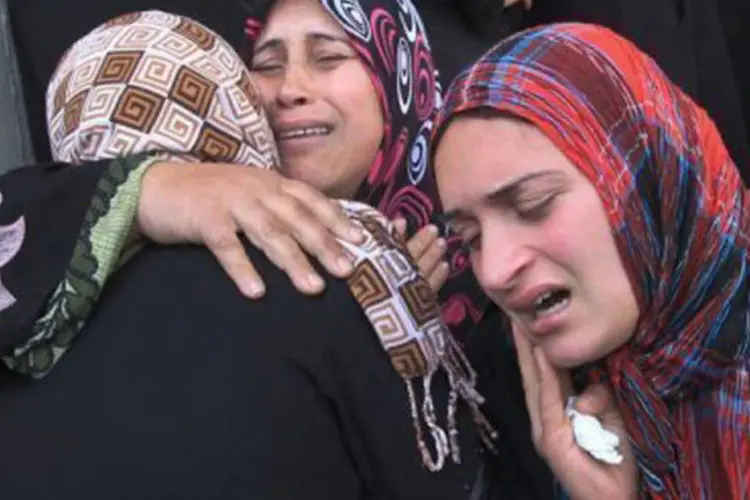 Mulheres palestinas choram no funeral de estudante de 12 anos morto em ataque israelense
 (Mahmud Hams/AFP)