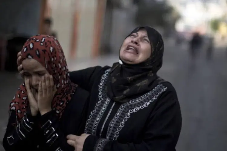
	Palestinas choram ap&oacute;s bombardeio israelense em escola de Gaza
 (AFP/Getty Images)