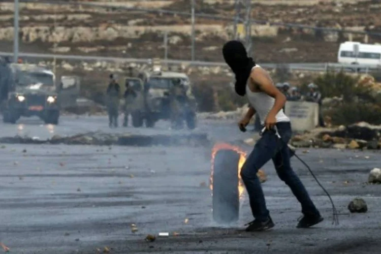 Um manifestante palestino entra em confronto com forças de segurança israelenses na Cisjordânia (Abbas Momani/AFP)