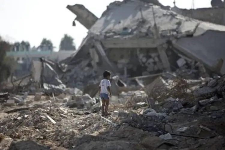
	Menino palestino caminha sobre escombros, em Gaza: Sara tinha 3 anos de idade
 (Mahmud Hams/AFP)