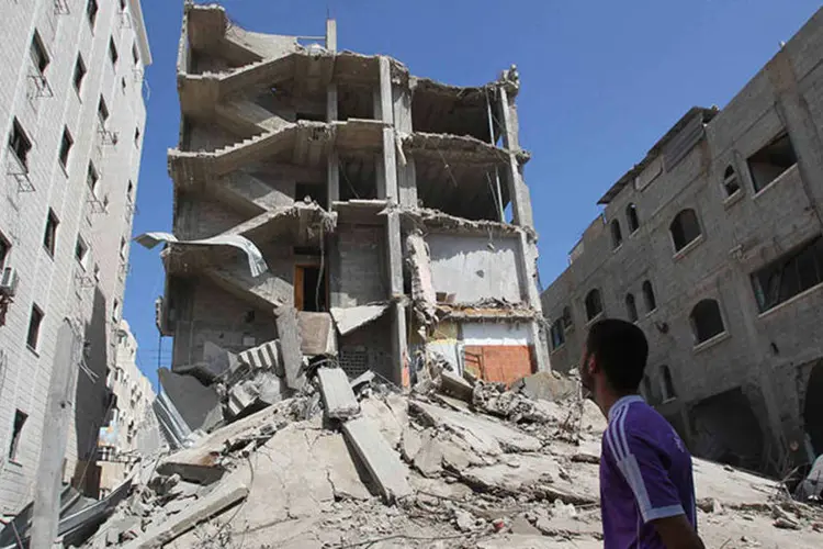 Palestino olha para prédio destruído após ataque israelense em Gaza  (REUTERS/Ahmed Zakot)