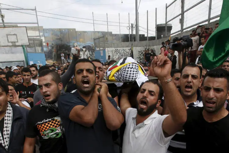 
	Palestinos carregam corpo de crian&ccedil;a morta pelo ex&eacute;rcito de Israel: ministro justifica que &quot;muitos deles santificam a morte&quot;
 (Reuters / Mussa Qawasma)