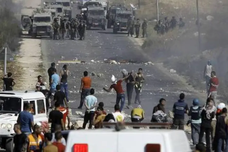 Palestinos enfrentam guardas de fronteira israelenses na Cisjordânia (Musa al-Shaer/AFP)