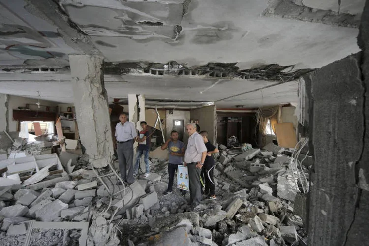 
	Palestinos em casa destru&iacute;da pelo ex&eacute;rcito israelense: as destrui&ccedil;&otilde;es de resid&ecirc;ncias acontecem em plena espiral de viol&ecirc;ncia na Cisjord&acirc;nia ocupada e Jerusal&eacute;m Oriental
 (Reuters / Ammar Awad)