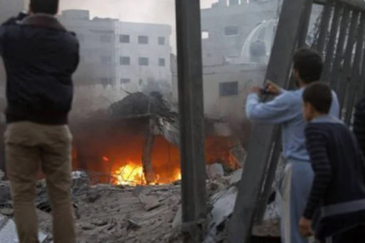 
	Palestinos fotografam a destrui&ccedil;&atilde;o ap&oacute;s ataque israelense em Gaza: desde o in&iacute;cio da ofensiva, morreram 90 pessoas - 87 palestinos e tr&ecirc;s israelenses
 (Mohammed Abed/AFP)