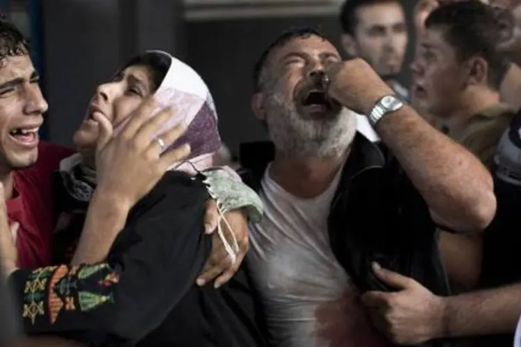 
	Palestinos choram pela morte de sete crian&ccedil;as em um campo de refugiados
 (Mahmud Hams/AFP)