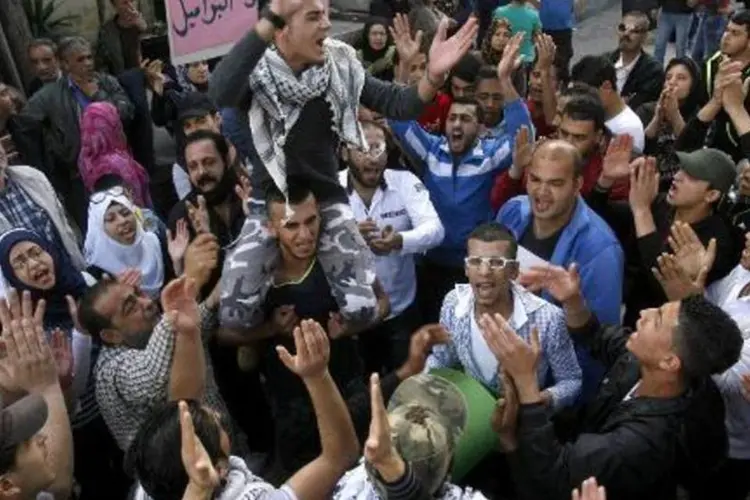 Palestinos refugiados do campo de Ain Al-Helwehm, no Líbano, participam de protesto contra a violência no campo de refugiados de Yarmuk (Mahmoud Zayyat/AFP)