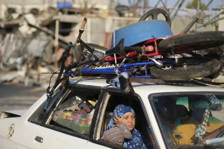 Palestinos retornam a suas casas: 2.139 pessoas, a maioria civis, incluindo mais de 490 crianças, foram mortas no enclave desde 8 de julho (Suhaib Salem/Reuters)