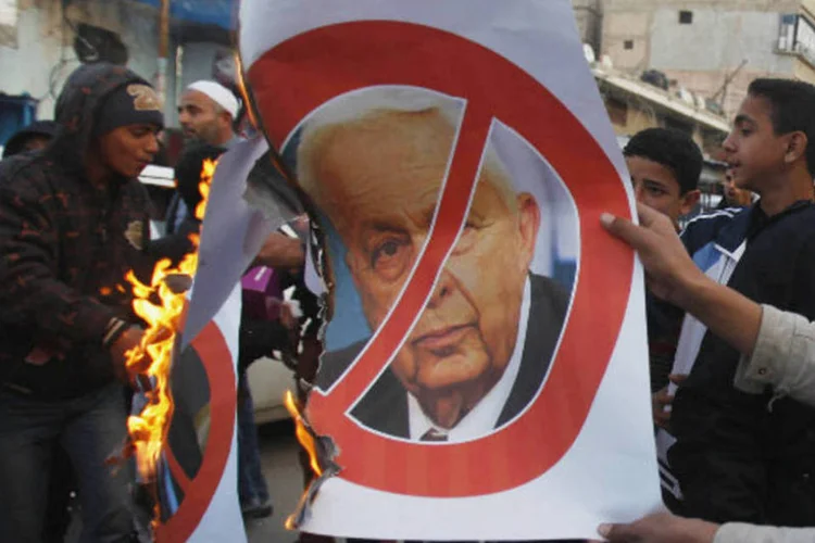 Palestinos queimam cartaz com imagem de Ariel Sharon, ex-primeiro ministro de Israel morto neste sábado (REUTERS/Ibraheem Abu Mustafa)