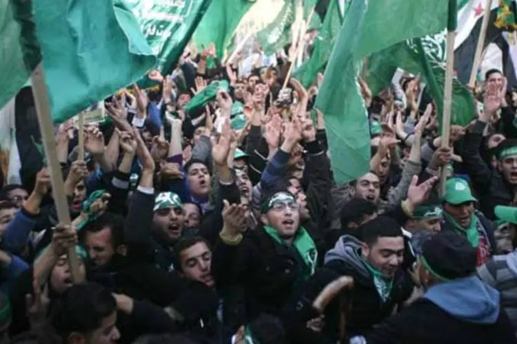 
	Palestinos erguem bandeiras do Hamas durante protesto:&nbsp;Israel acusou o Ir&atilde; e a S&iacute;ria de estarem por tr&aacute;s do envio de dezenas de foguetes
 (REUTERS/Muammar Awad)