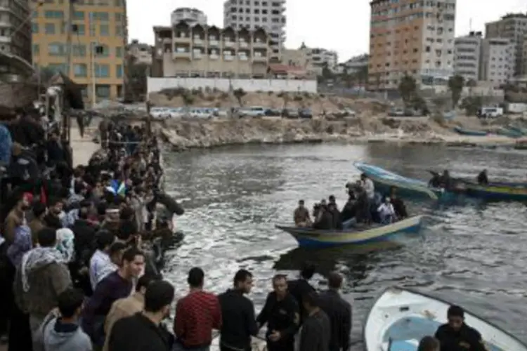 Palestinos observam partida da flotilha, no porto de Gaza: organizadores disseram que, "ao contrário das flotilhas que tentaram romper o cerco do exterior, esta partiu da cidade de Gaza" (AFP)