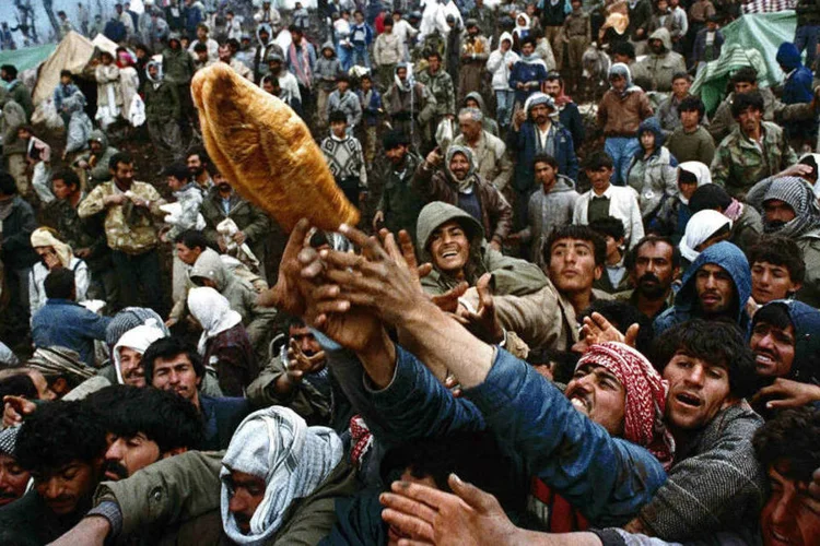 Refugiados curdos lutam por pão durante distribuição de ajuda humanitária na fronteira entre o Iraque e a Turquia, em abril de 1992 (Yannis Behrakis/Reuters)