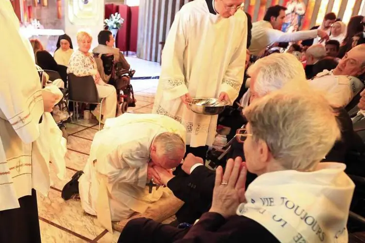 Papa Francisco beija o pé de um idoso na Igreja de Santa Maria Mãe da Providência, em Roma, durante as celebrações da Quinta-Feira Santa (Tony Gentile/Reuters)