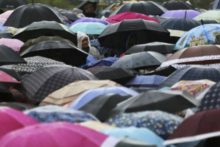 Católicos aguardam na chuva a chegada do papa Francisco a Aparecida do Norte, interior de São Paulo (24/julho/2013) (Nacho Doce/Reuters)