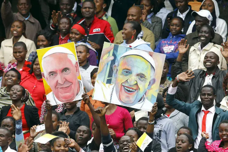 Pessoas seguram cartazes com retratos do papa Francisco no Quênia (Stefano Rellandini/REUTERS)
