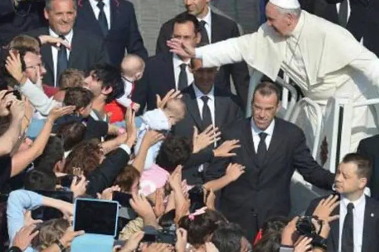 Papa Francisco cumprimenta a multidão na Praça de São Pedro (©afp.com / ALBERTO PIZZOLI)