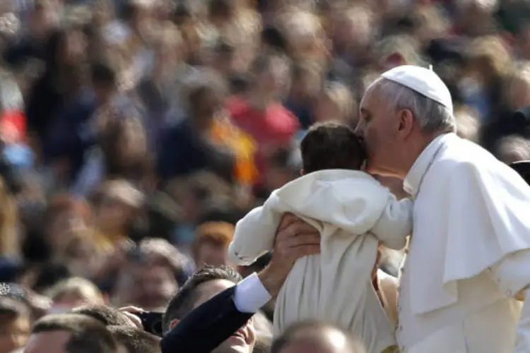 Papa Francisco beija criança ao chegar à Praça de São Pedro, no Vaticano (REUTERS/Stefano Rellandini)