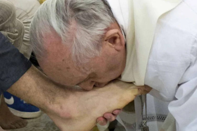 Papa beija pés de fiéis: o Papa participará também da Via Crucis em torno do Coliseu romano na sexta-feira à noite, que deve ser transmitida ao vivo por diversas redes de televisão de vários países. (REUTERS/Osservatore Romano)