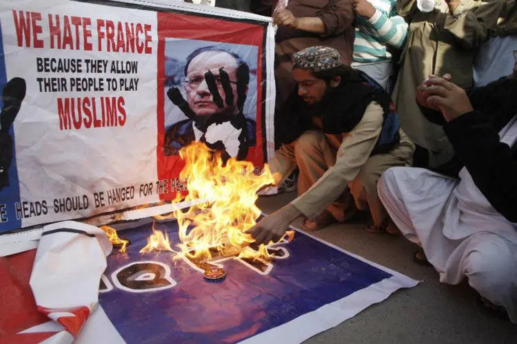 
	Paquistaneses queimam bandeiras da Fran&ccedil;a e fotos do presidente Fran&ccedil;ois Hollande: Milhares criticam novas charges de Maom&eacute; publicadas pela Charlie Hebdo ap&oacute;s atentado
 (REUTERS/ Naseer Ahmed)