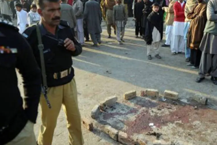 
	Policiais paquistaneses e moradores observam &aacute;rea de atentado suicida durante prociss&atilde;o xiita em Rawalpindi: &nbsp;os xiitas s&atilde;o alvos frequentes dos ataques
 (Aamir Qureshi/AFP)