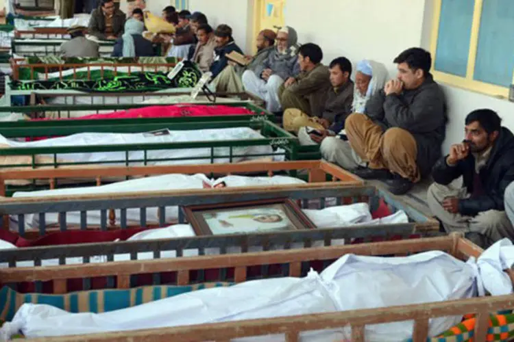 
	Paquistaneses de luto sentam ao lado dos caix&otilde;es de seus familiares em Quetta, Paquist&atilde;o: o atentado de Quetta foi o mais mort&iacute;fero desde 13 de maio de 2011
 (Banaras Khan/AFP)