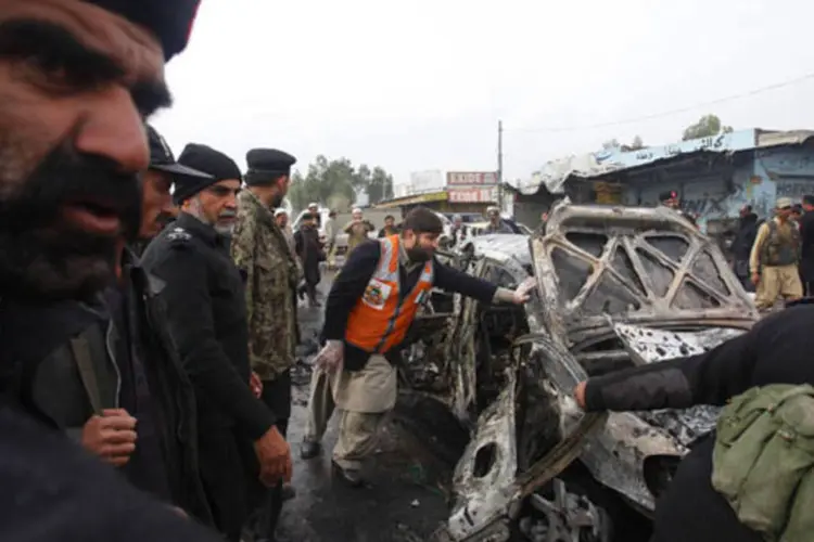 
	Policiais tentam movimentar carro danificado ap&oacute;s ataque com bomba 
 (Fayaz Aziz/Reuters)
