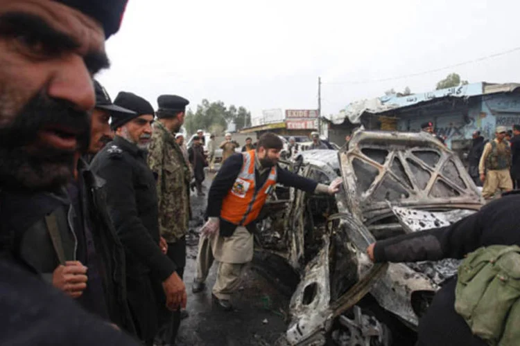 
	Policiais tentam movimentar carro danificado ap&oacute;s ataque com bomba 
 (Fayaz Aziz/Reuters)